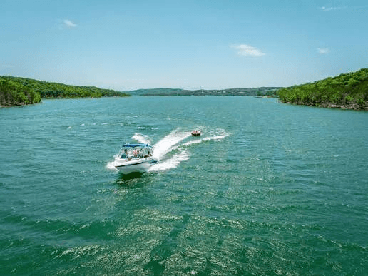 Boat cruising on Table Rock Lake with tubers on the water